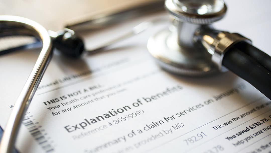 Doctors stethoscope on top of insurance paperwork